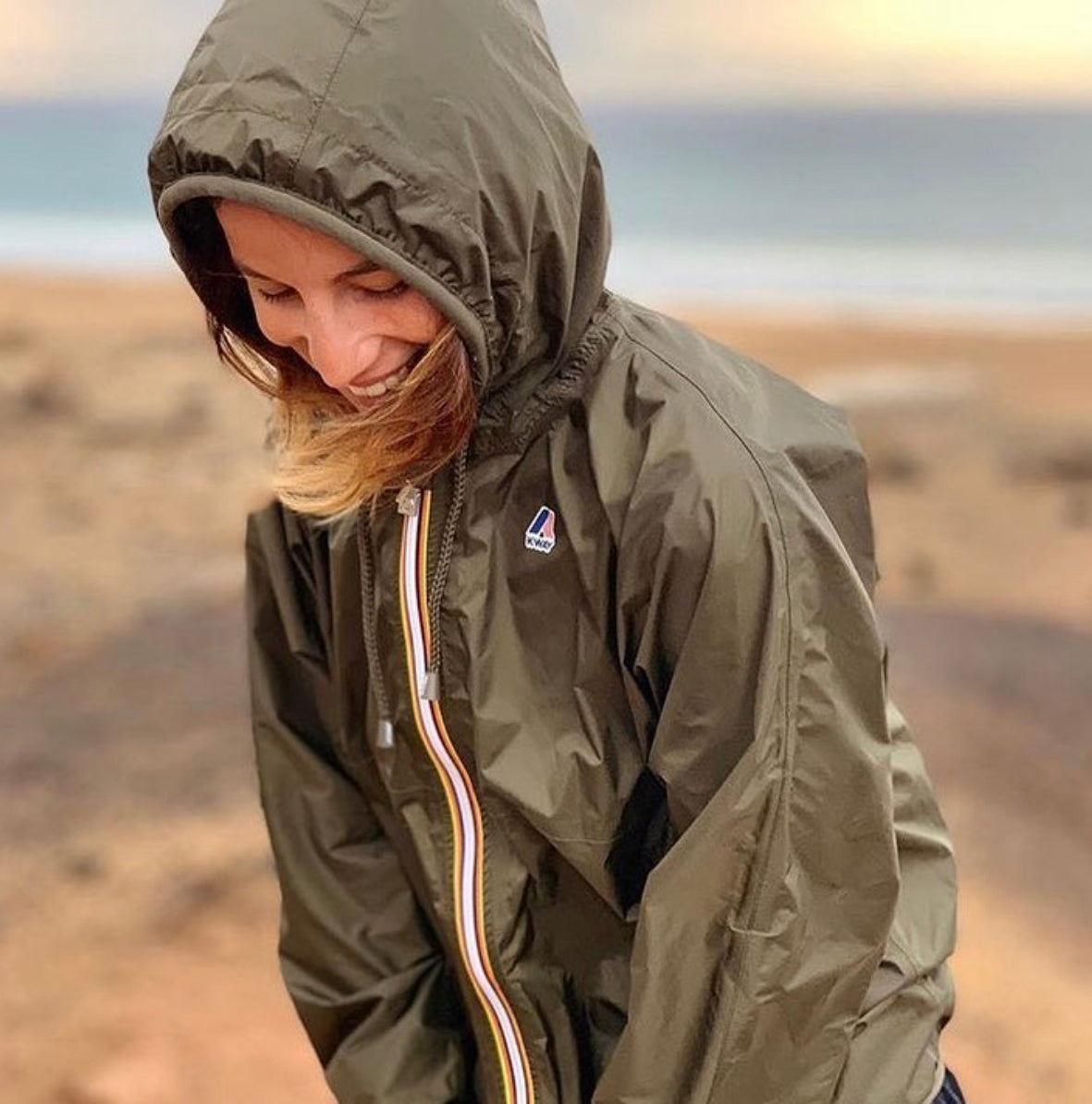 Women in a desert wearing a hooded Claude K-Way Jacket in Dark Brown Olive