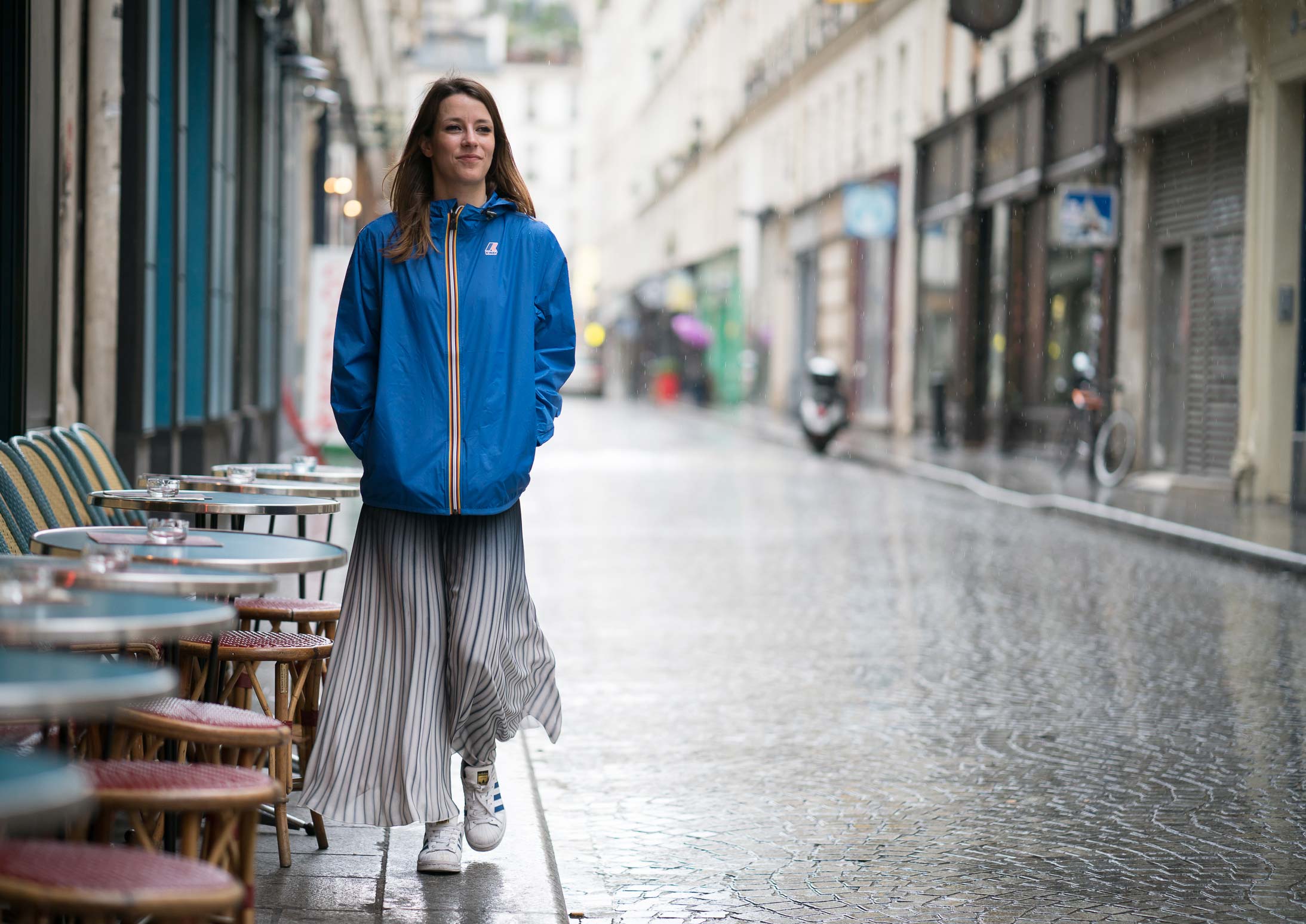 Women wearing a Blue Royal Le Vrai Claude K-Way (Kiwi) Jacket in rainy weather in Paris